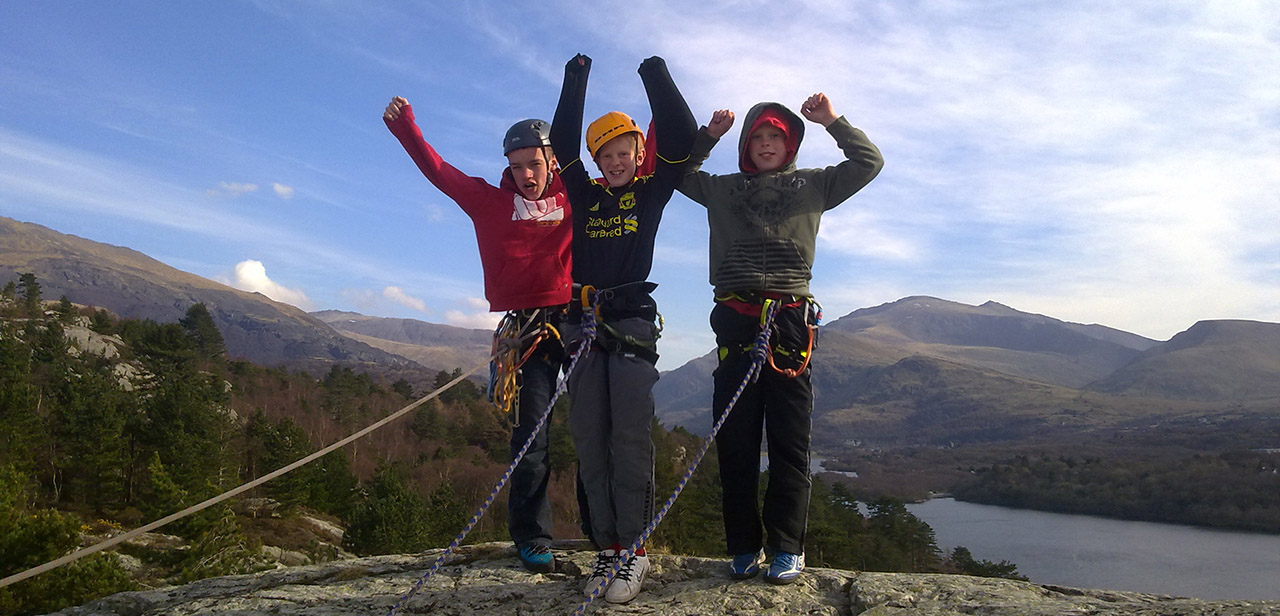 A young team celebrate upon reaching the top of their first climb