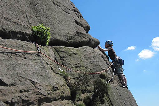 A small image of a climber traversing across a cliff