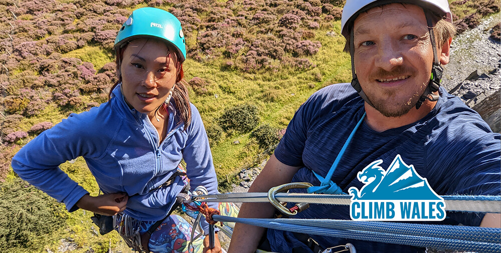 A female rock climber abseils with a heavy male casualty