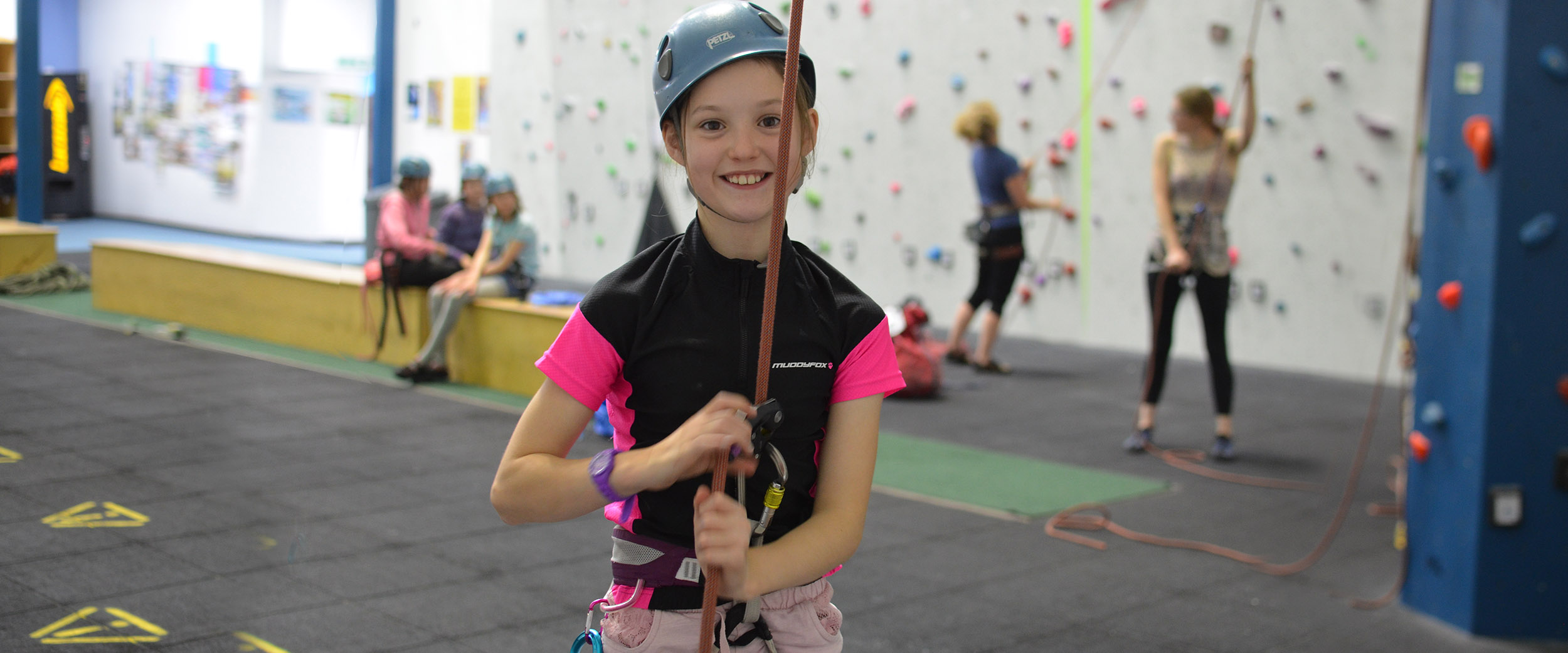 A young girl at an indoor climbing wall