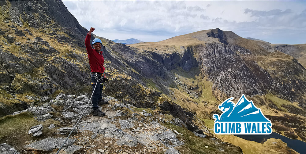 A happy customer punching the air with joy after scrambling up the Cneifion Arete in Ogwen, Snowdonia