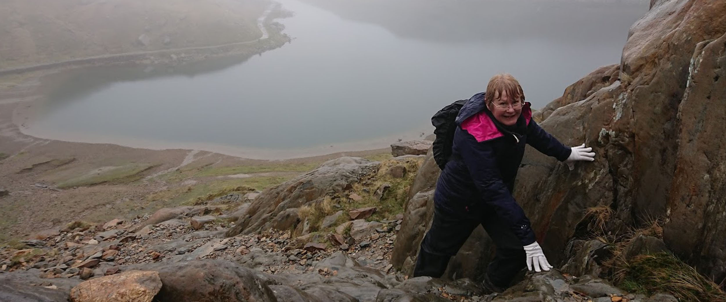 A lady making her way up Snowdon for the first time. Despite what looks like a damp day she is smiling