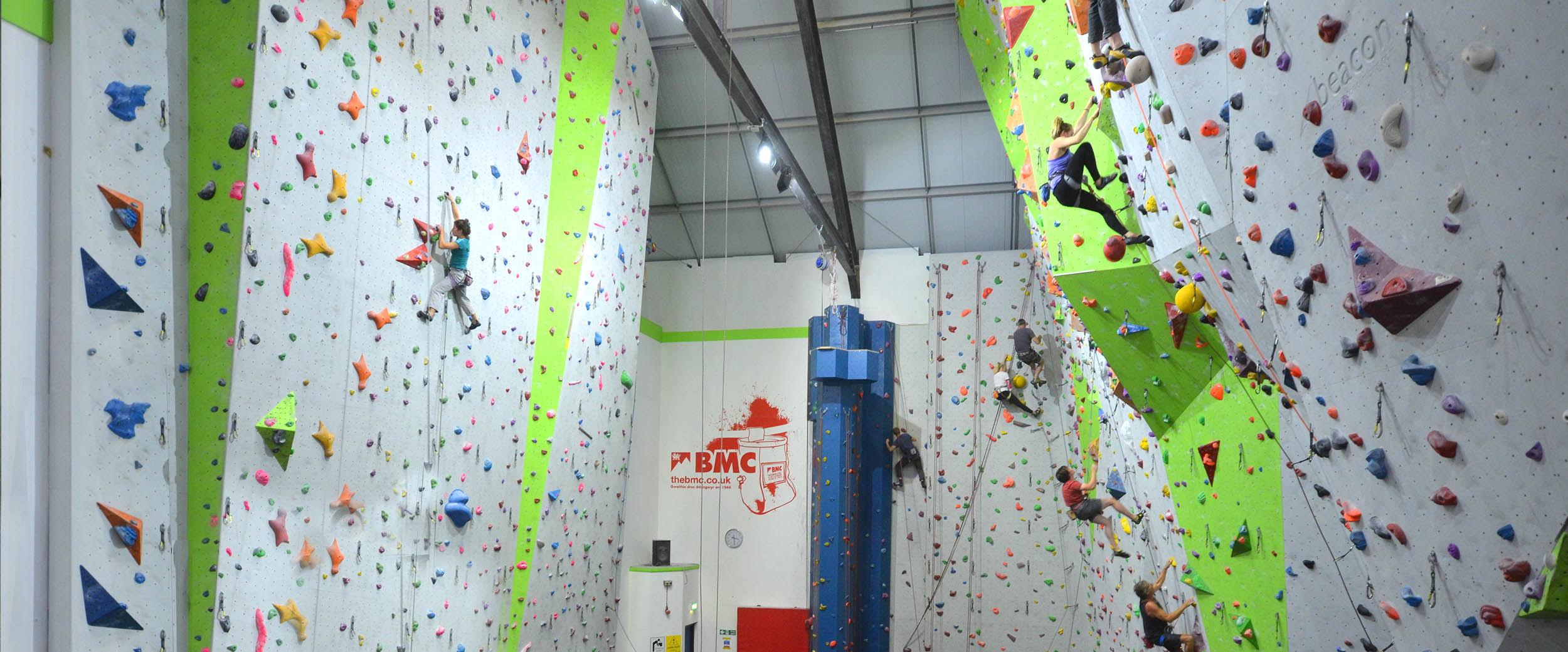 A young girl appears to be extremely focused as she makes her way across a short climbing wall