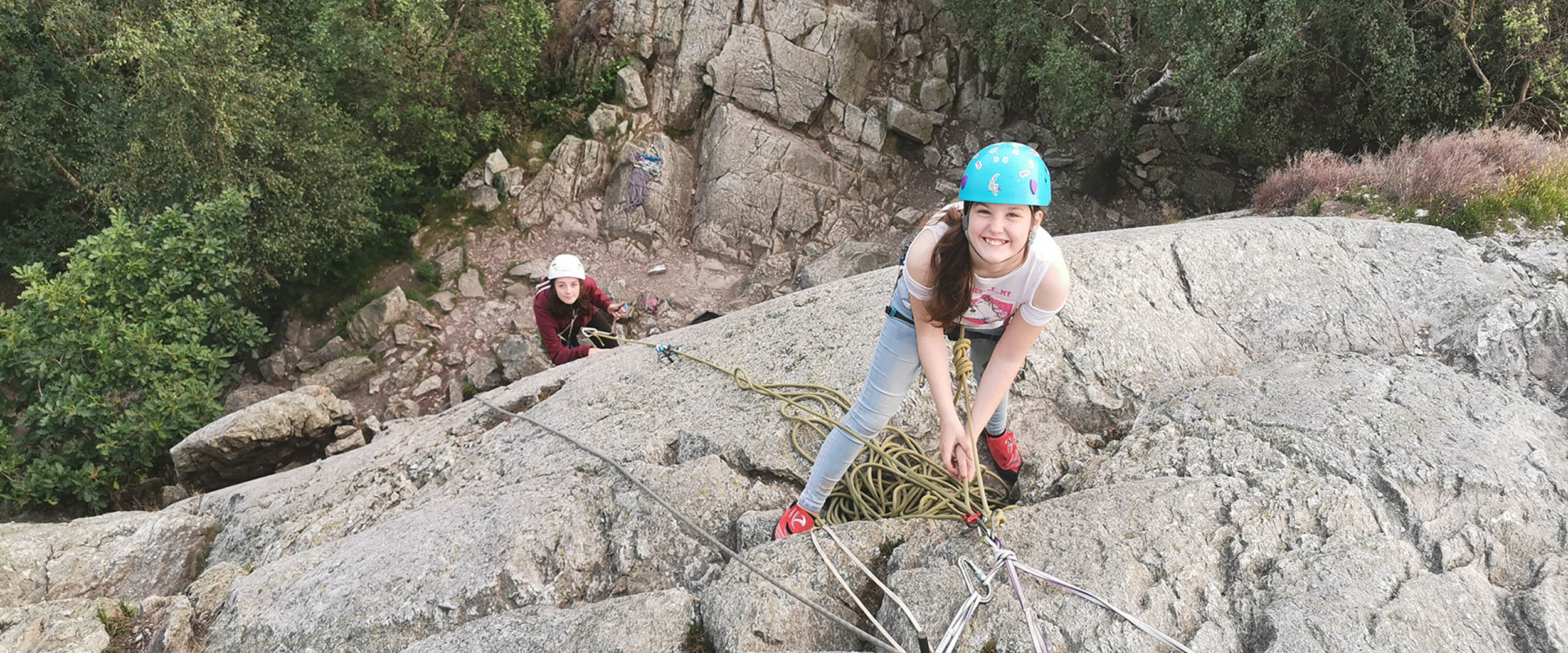 Two young girls climbing, one hasn't oticed a cross-loaded carabiner
